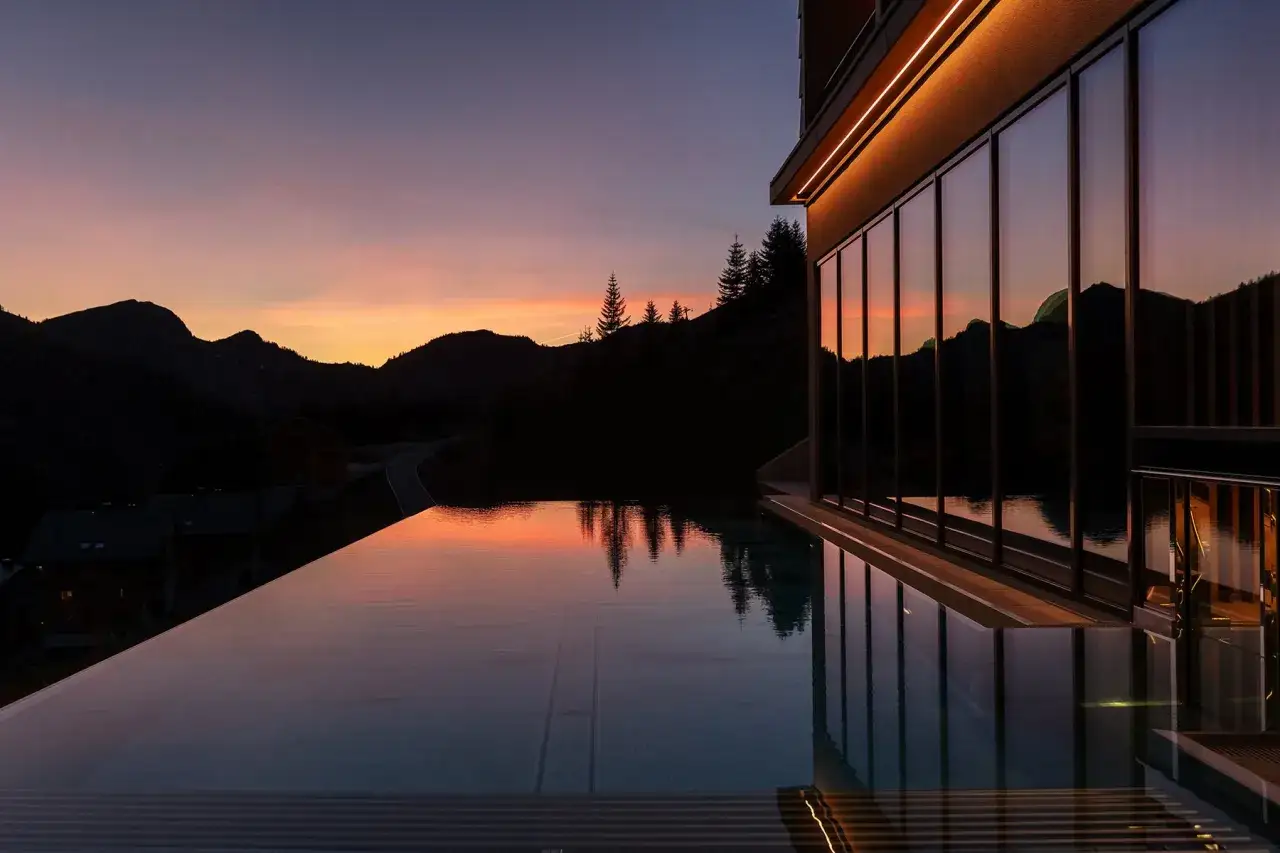 Infinity Pool mit Bergblick bei Sonnenuntergang in einem Wellnesshotel